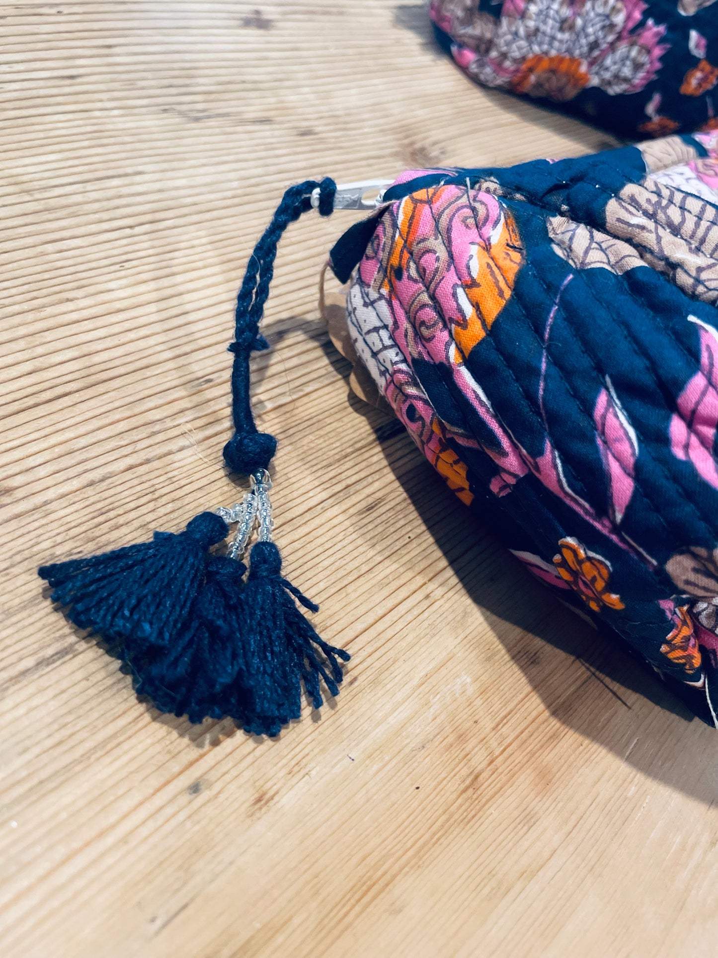 Praktische blaue Kulturtasche im Ripp-Design mit rosa Blumen und beigen Ranken. Innen mit einem wasserfesten Bezug und zwei kleinen Fächern!