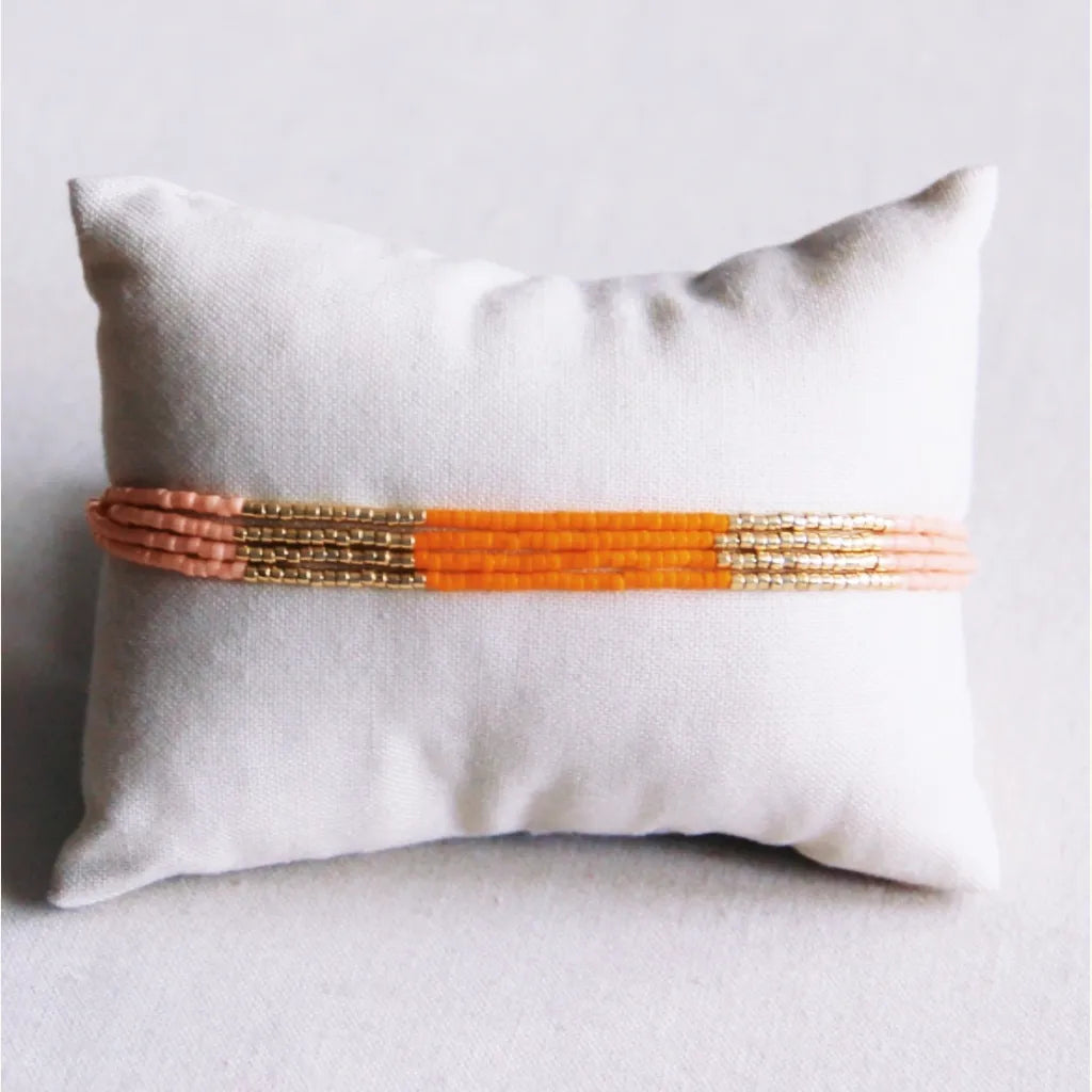 Vierfaches Miyuki-Armband in orange, Lachs Muster mit goldenen Akzenten. Grössenverstellbar mit Schiebeknoten