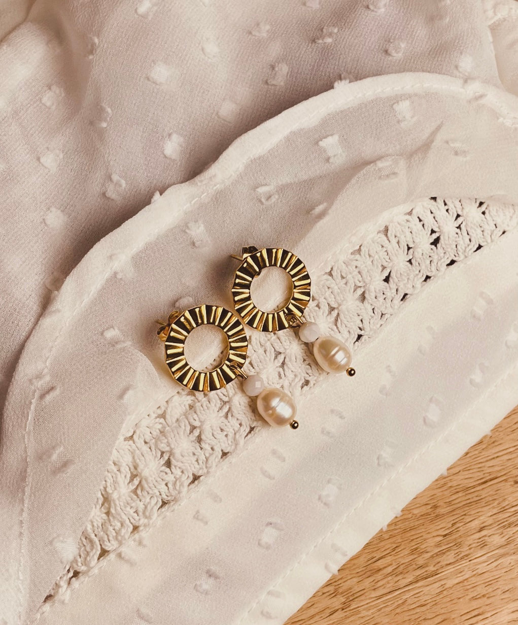 Ohrstecker aus goldenem Edelstahl aus einem gewelltem Ring an den ein kleiner runder Jade Stein und ein Perle angehängt ist.