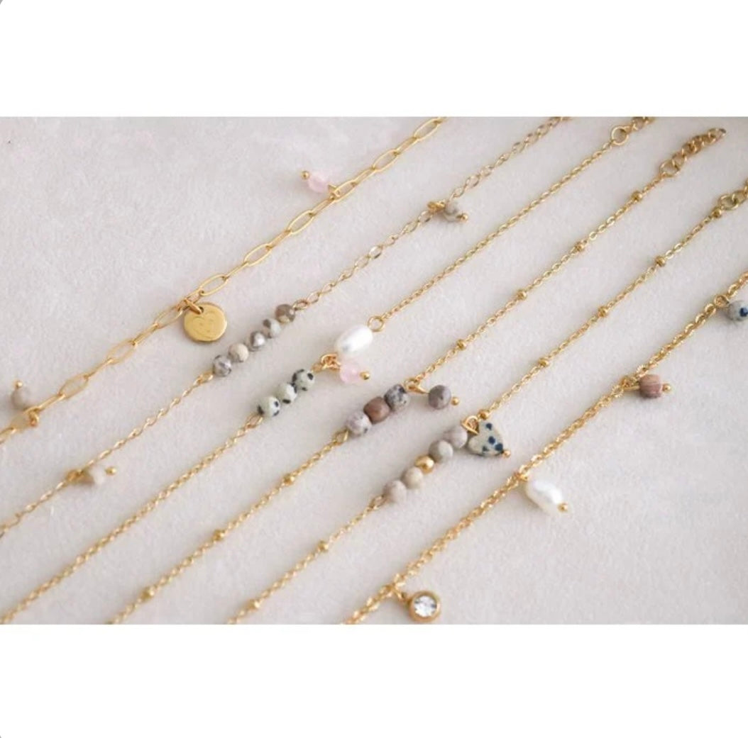 Jaspis-, Perlen- und Rosenquarzarmband in Gold, aus Edelstahl. Die dalmatinischen Jaspissteine und der Rosenquarzstein sind facettiert geschliffen und glänzen wunderschön. Die Perle ist eine echte Süßwasserperle.