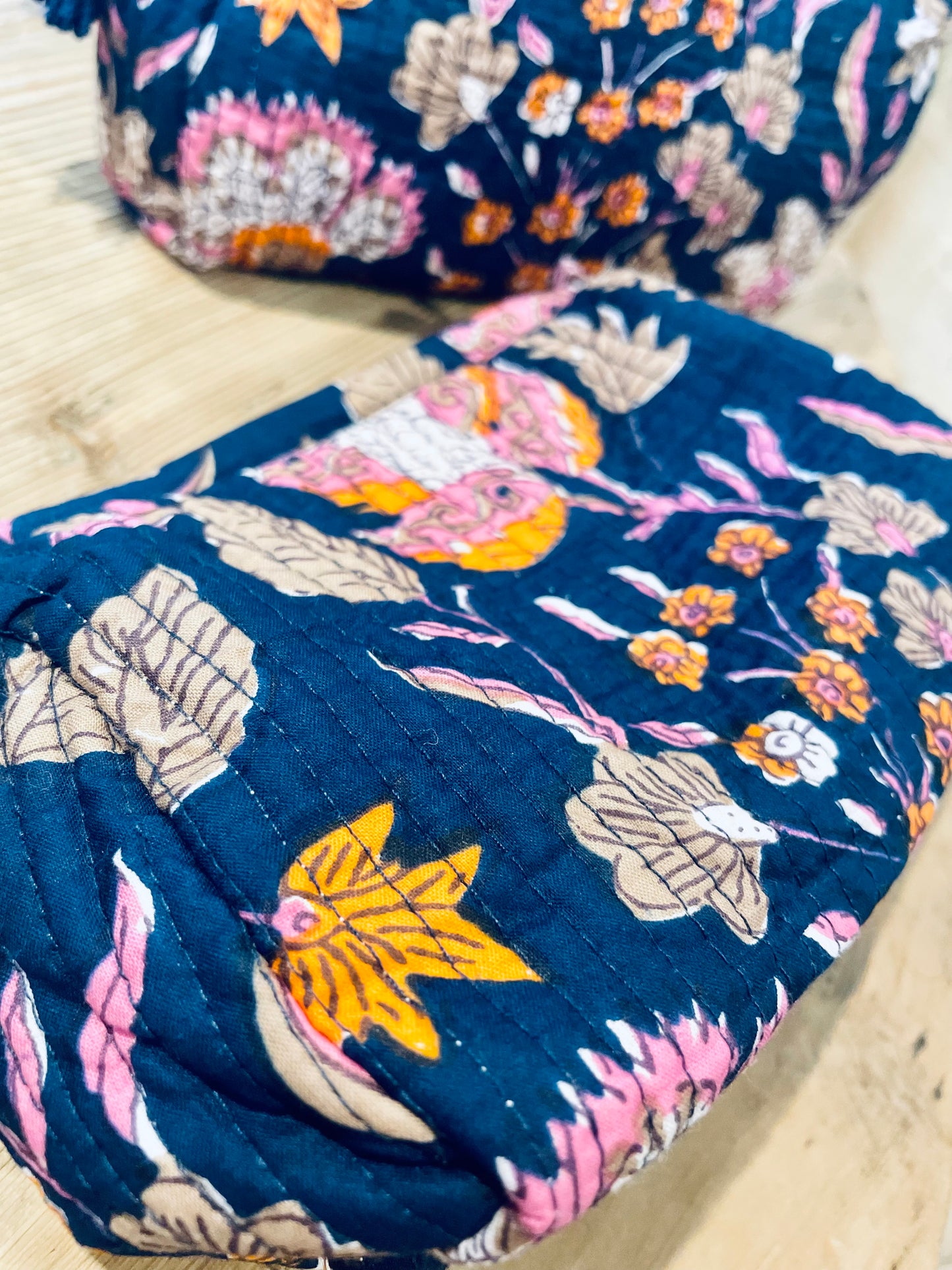 Praktische blaue Kulturtasche im Ripp-Design mit rosa Blumen und beigen Ranken. Innen mit einem wasserfesten Bezug und zwei kleinen Fächern!