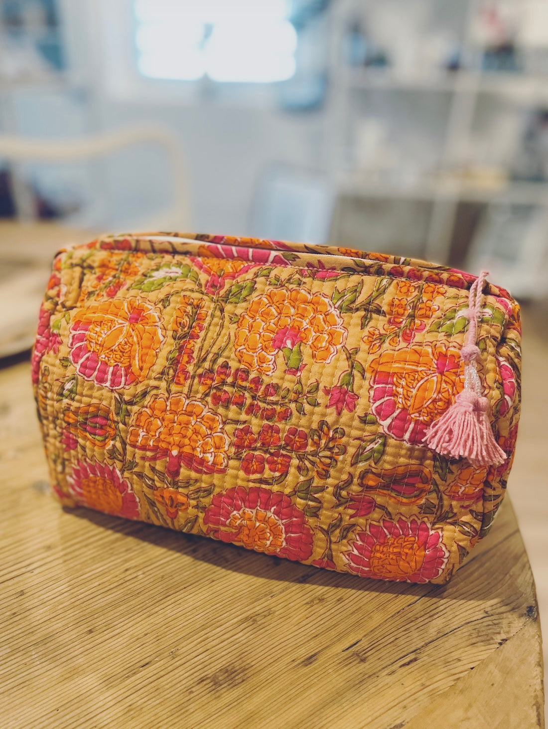 Praktische knallig orange Kulturtasche im Ripp-Design mit pinken Blumen. Innen mit einem wasserfesten Bezug und zwei kleinen Fächern!