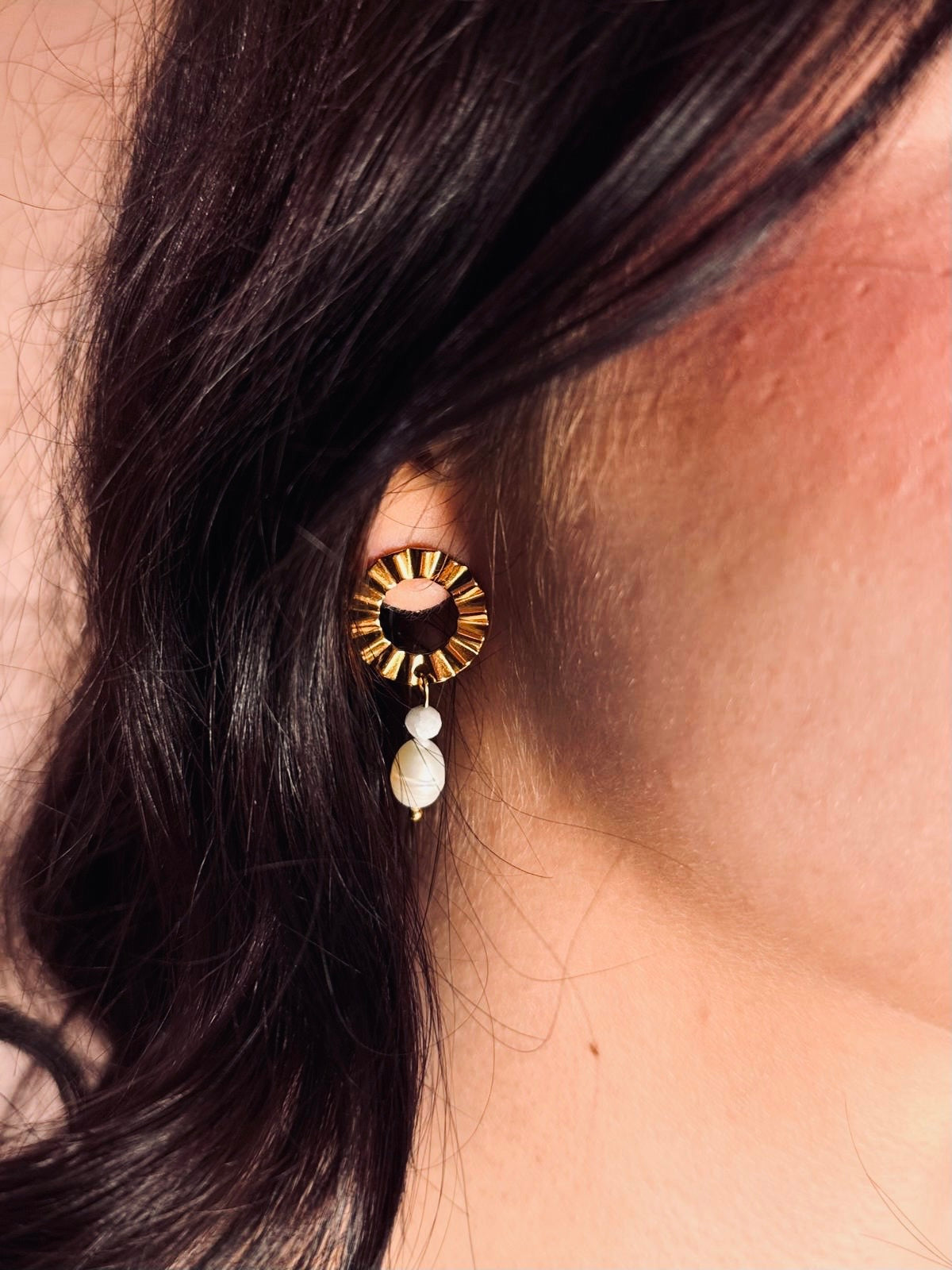 Ohrstecker aus goldenem Edelstahl aus einem gewelltem Ring an den ein kleiner runder Jade Stein und ein Perle angehängt ist.
