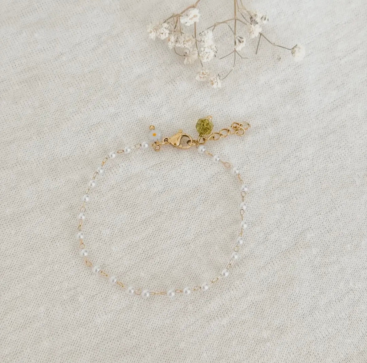 Perlchen Armband mit kleinen Perlen rundherum und Eselstahl Kettchen. Den Verschluss zieren zwei Steine. Ein facettierter Peridot-Stein und ein kleines Gänseblümchen-Perlchen