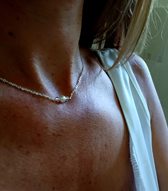 Silberne Rücken Halskette mit feiner Gliederkette mit einer Perle und zwei klaren Kristallperlen vorne. Im Rückenbereich mit drei unterschiedlich langen hängenden Gliederketten, am Ende mit je drei unterschiedlich großen Perlen! Rückenteil ist abnehmbar !