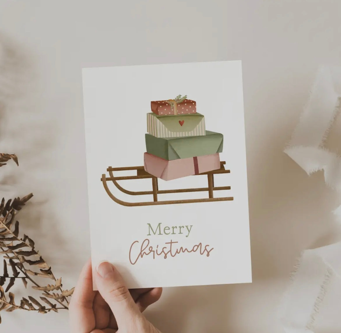 Weihnachtskarte: Merry Christmas. Schlitten mit bunten Päckchen. Gedruckt auf Naturpapier.