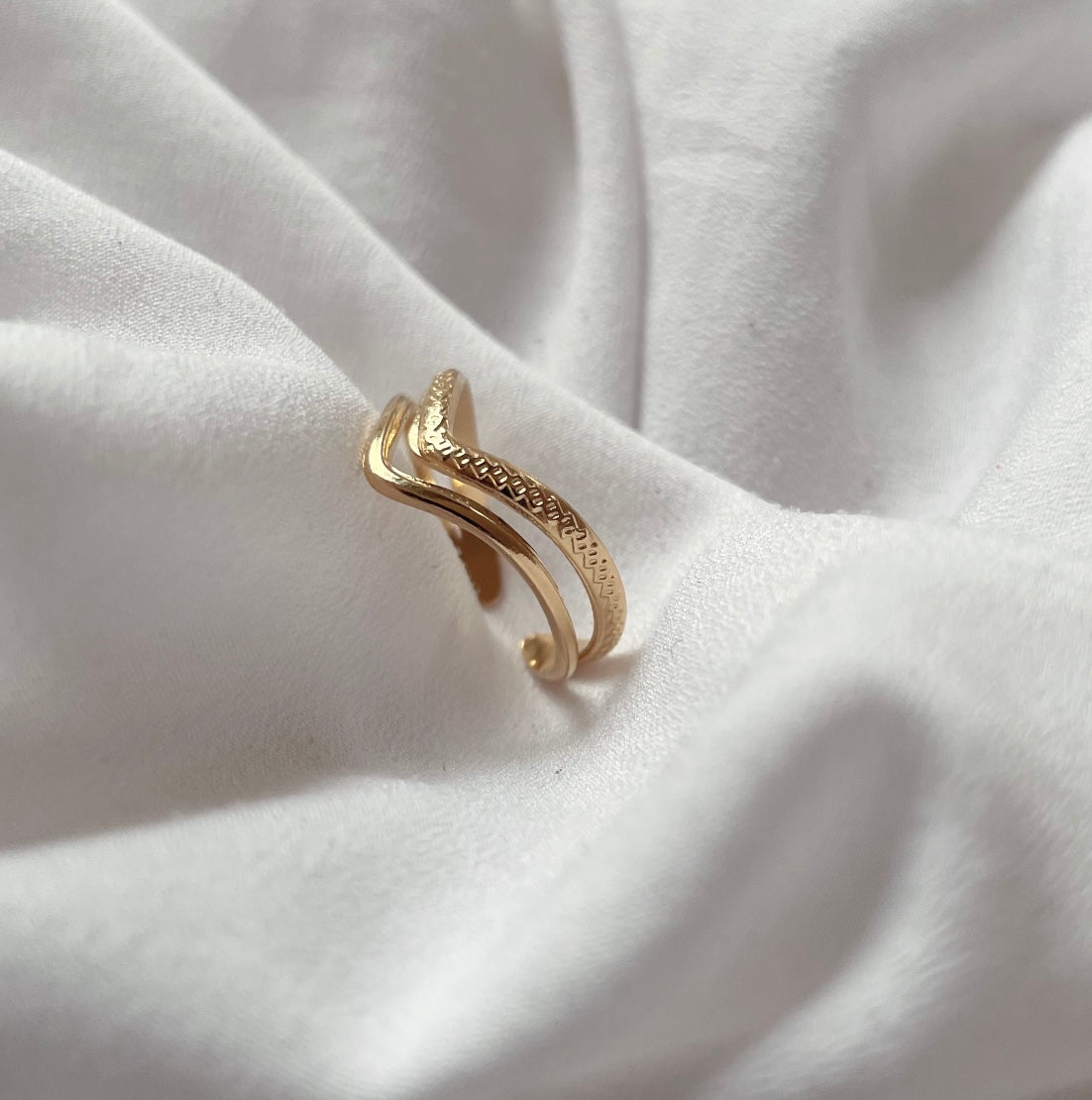 Edelstahl Goldring besteht aus zwei Reihen. Einer hoch glänzenden und einer leicht strukturierten Reihe. Beide sind mit einander verbunden und laufen spitz zu.