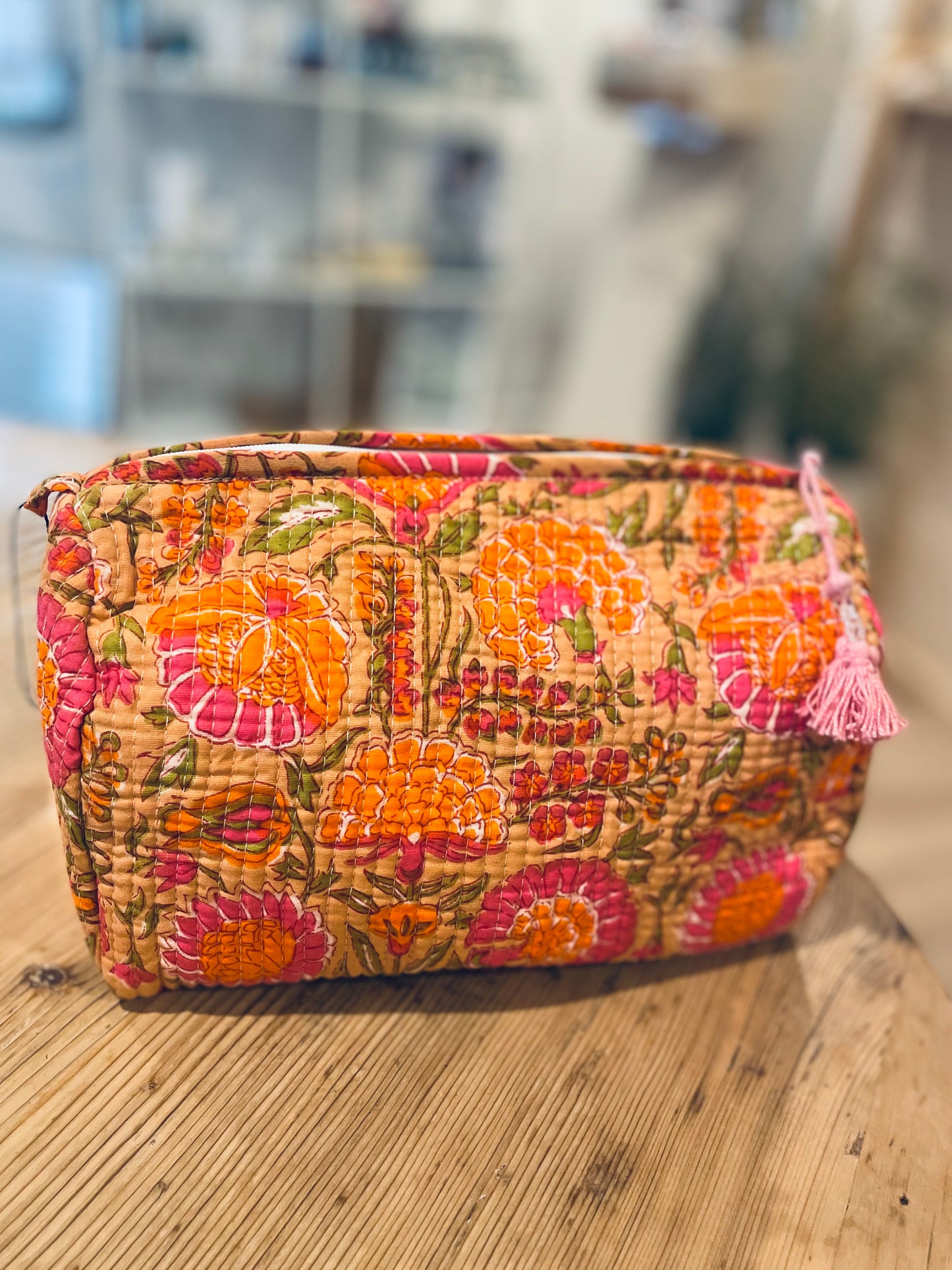 Praktische knallig orange Kulturtasche im Ripp-Design mit pinken Blumen. Innen mit einem wasserfesten Bezug und zwei kleinen Fächern!