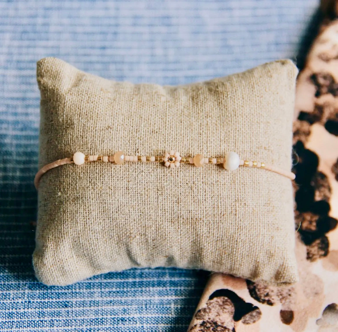 Miyuki-Armband in den Farben Nude und Gold mit facettierte Perlen und eine Gänseblümchenblume. Mit Schiebeknoten individuell verstellbar.