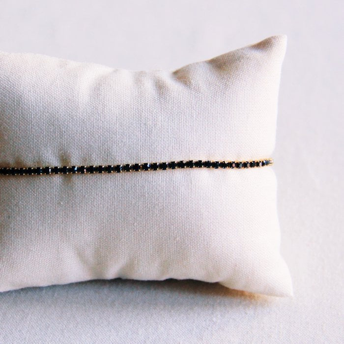 Feines Flussarmband gearbeitet aus vergoldetem Edelstahl mit schwarzen Strasssteinen