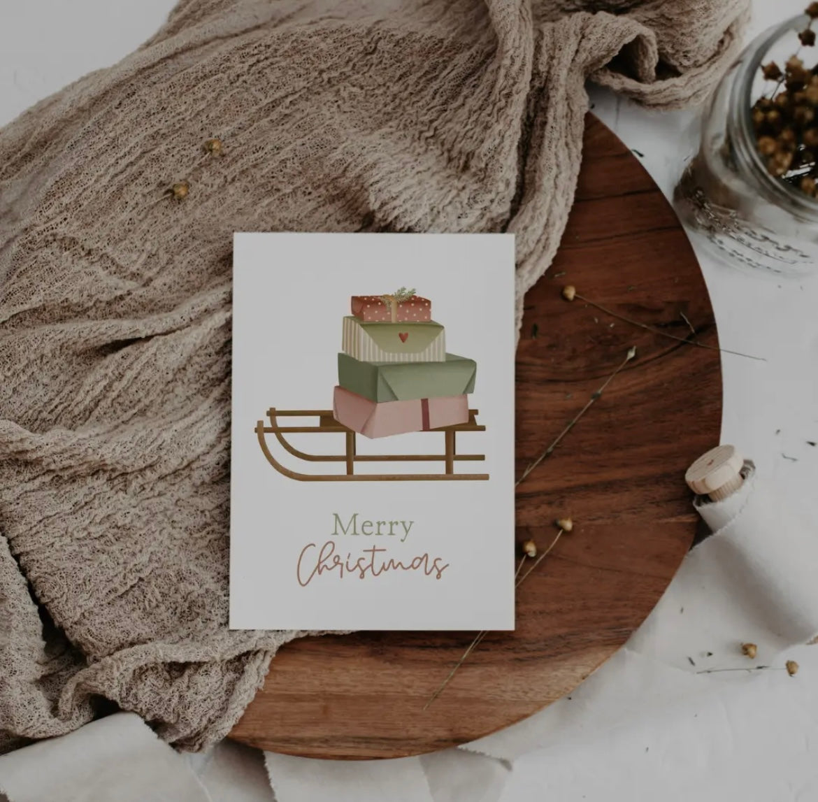 Weihnachtskarte: Merry Christmas. Schlitten mit bunten Päckchen. Gedruckt auf Naturpapier