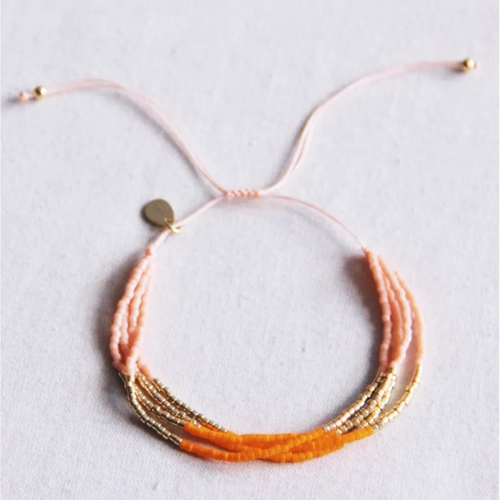 Vierfaches Miyuki-Armband in orange, Lachs Muster mit goldenen Akzenten. Grössenverstellbar mit Schiebeknoten