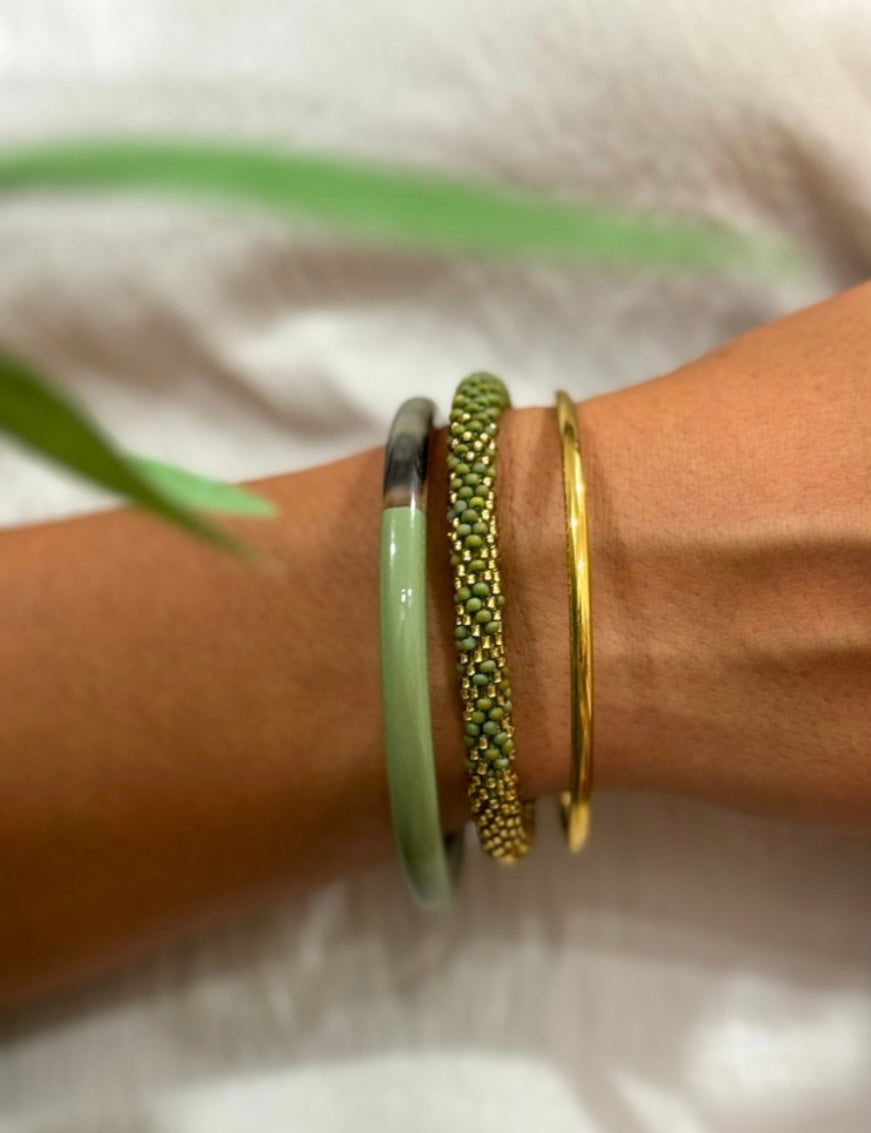 Handgefertigters Glasperlen Armband. In glänzendem grün mit goldenen Akzenten.