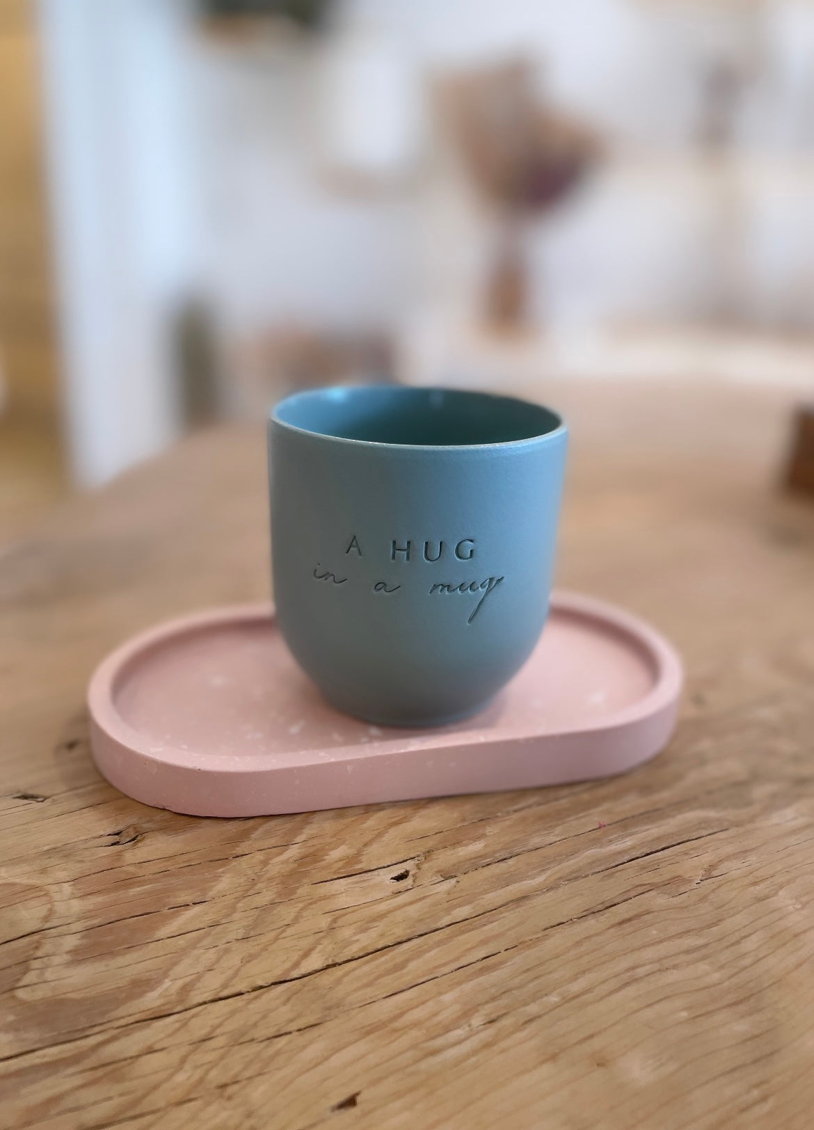 Handgemachter Keramik Becher von "Dear Benno" aus Steingut in der Farbe: Salbei Außen matt innen glänzend Dazu die Aufschrift: "A Hug in a Mug"
