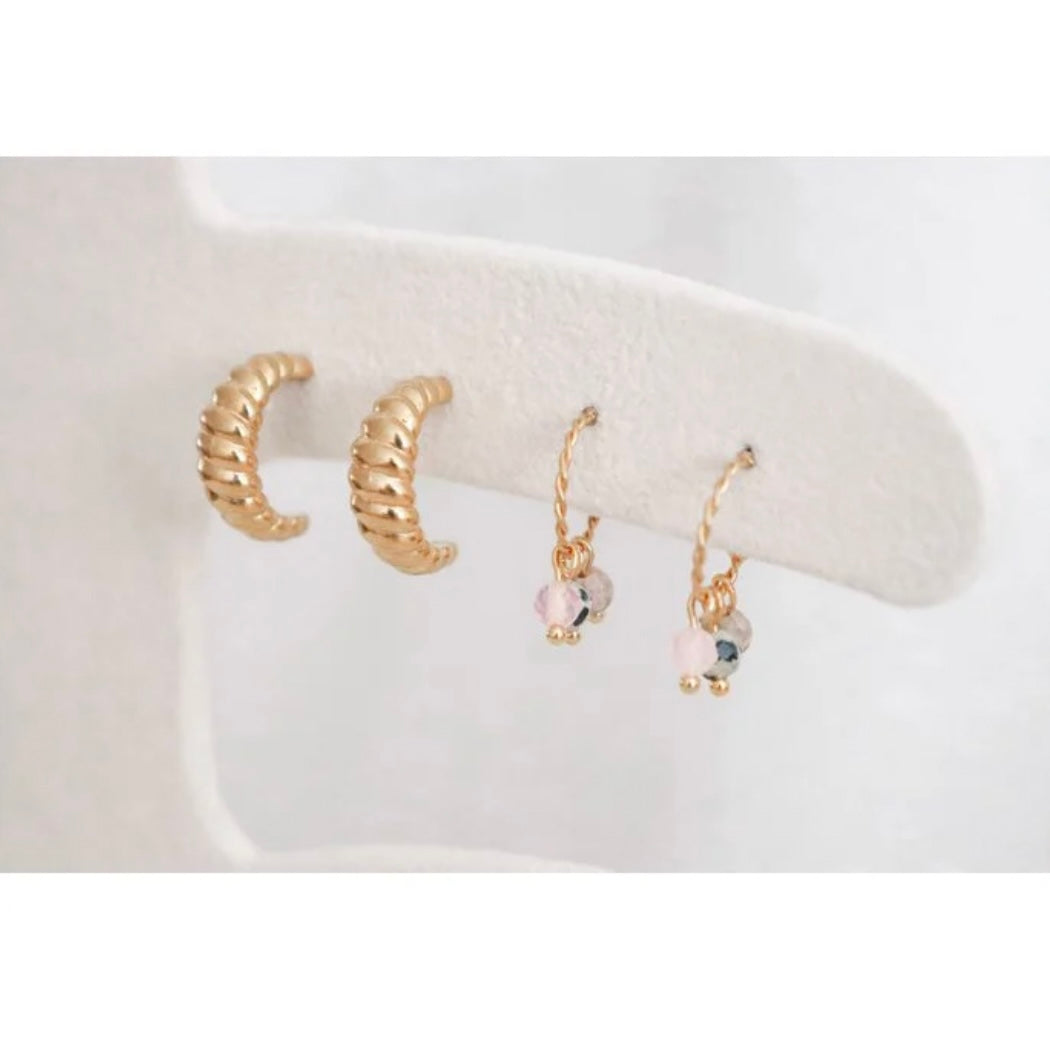 Balance Edelstein Ohrringe in Gold aus Edelstahl. Die Edelsteine auf den Ohrringen sind: Maifan, Rosenquarz und dalmatinischer Jaspis. Die Steine Rosenquarz und dalmatinischer Jaspis sind facettiert geschliffen und haben ein schönes Funkeln.