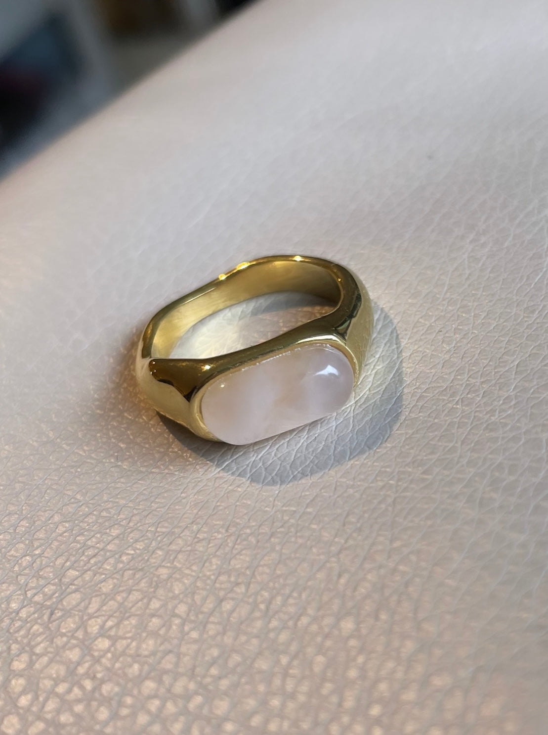 Edelstahl Ring in gold mit milchig schimmernden Stein in weiß, beige und creme.