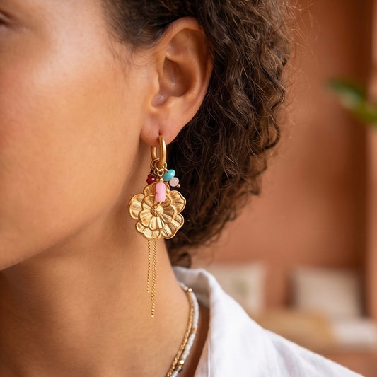 In die Click Creole ist eine große goldene Edelstahlblume eingehängt und zwei feine Gliedekettchen. Zudem ziert die Creole kleine Steinchen in Rosa & Mint. Alle Anhänger sind herausnehmbar.