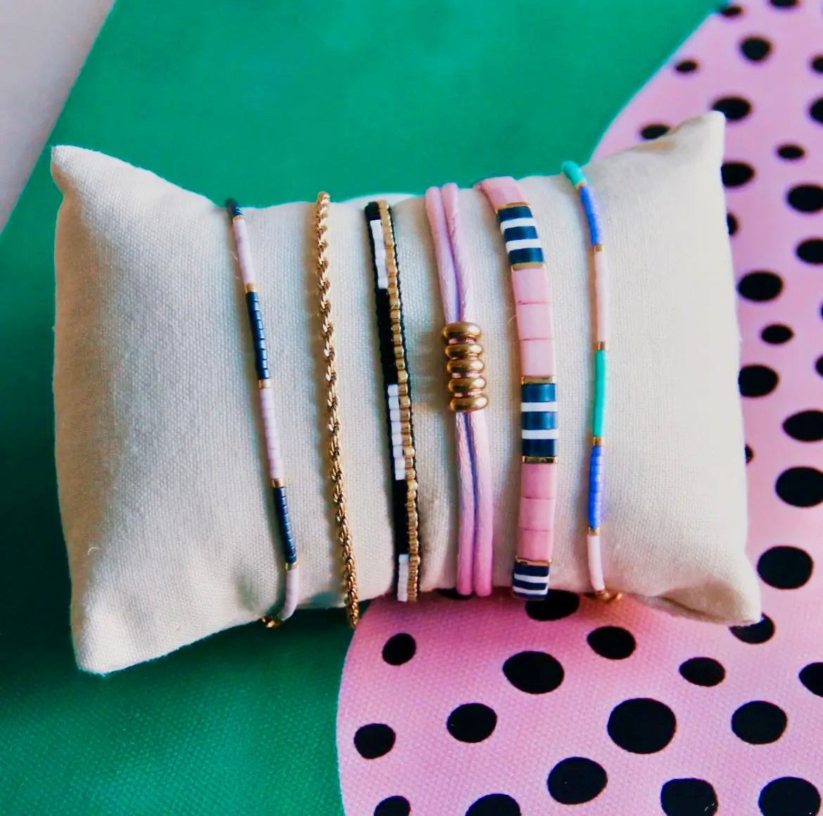 Tilabead-Armband in den knalligen Farben lila, grau und weiß mit vergoldeten Perlen. Mit Schiebeknöpfe individuell in der Größe verstellbar. 