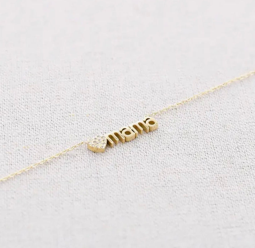 Feine goldene Edelstahl Kette  aus einer feinen Gliederkette mit einem Verlängerungskettchen. In der Mitte ist ein goldenes Herzchen mit kleinen Zirkoniasteinchen und dem Schruftzug „MAMA“ eingearbeitet.