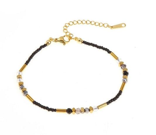 Schickes Edelstah Armband mit goldenen, schwarzen und klaren Perlen und Steinchen. Mit Karabiner Verschluss und Verlängerungskettchen.