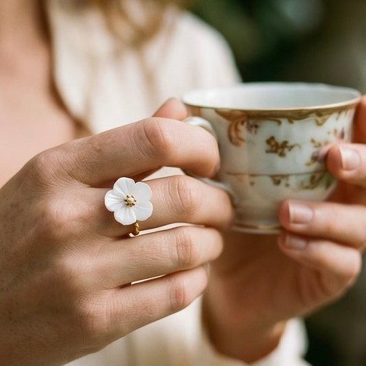  Auf den gedrehten Goldring ist eine Weiße Perlmutt Blüte angebracht mit einer goldenen Perle! 