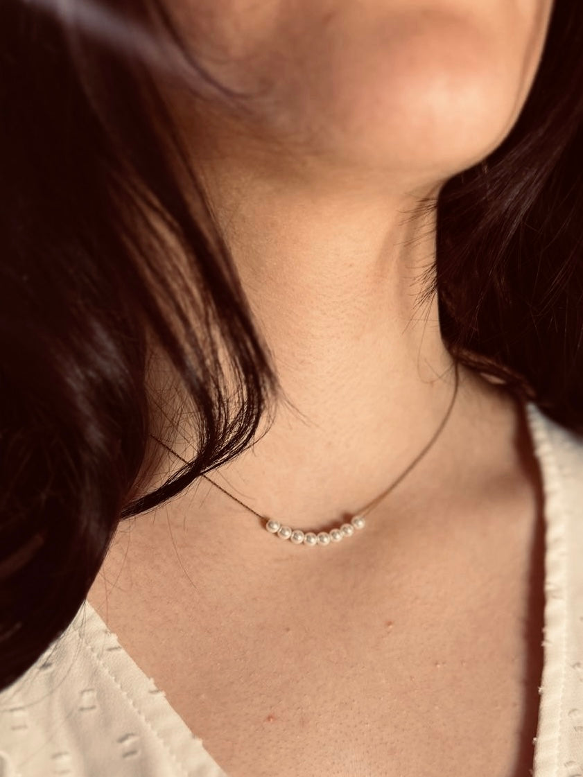 Filigrane Gold Edelstahl Kette mit acht weißen Perlen. 