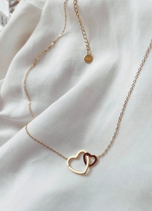Edelstahlkette mit zwei verbundenen Herzen. Ein größeres und ein Kleiners Herz sind in einander gehangen und an eine feine Gliederkette angebracht. 