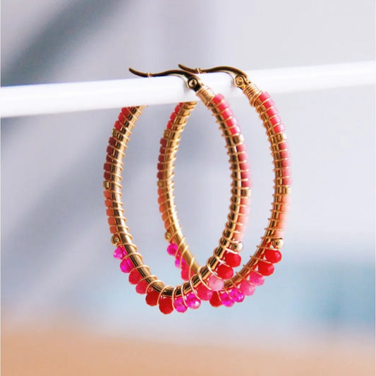Ovale Edelstahl Creole mit Miyuki Perlen im Facettenschliff und goldenen Edelstahlkügelchen. Mit rosa, rot und pink farbenen Miyukis.