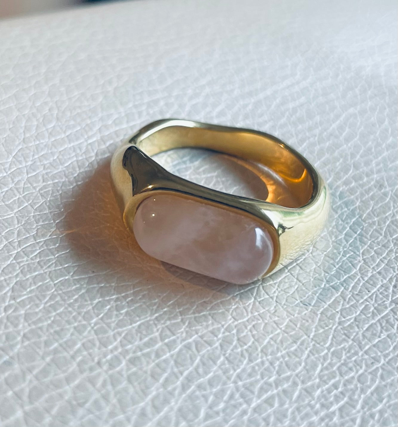 Edelstahl Ring in gold mit milchig schimmernden Stein in weiß, beige und creme.