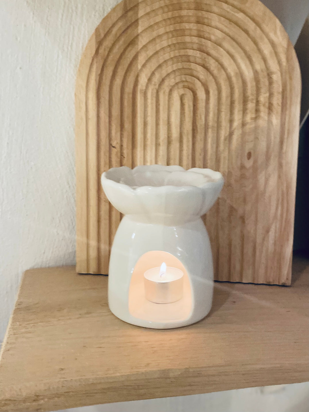 Weiße Keramik Duftlampe mit Pfingstrose, Frontansicht mit Holz Hintergrund