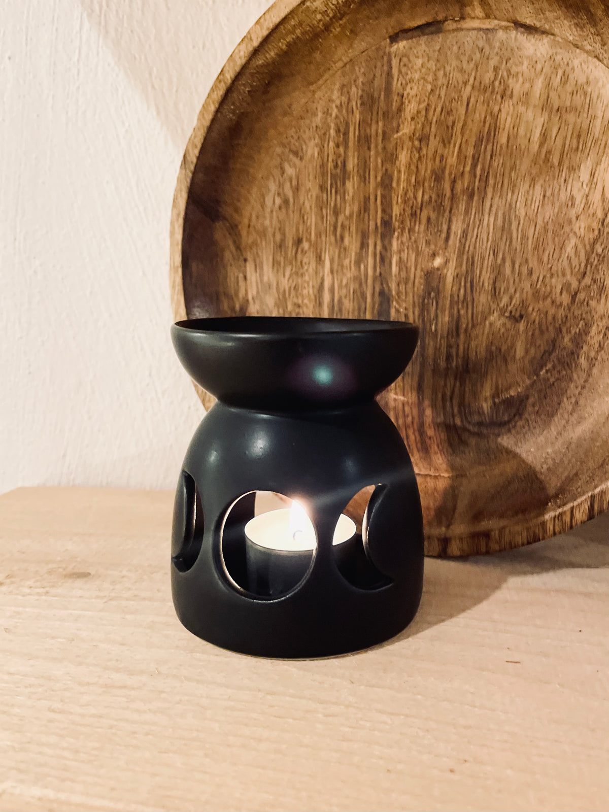 Matte Duftlampe aus Keramik in Schwarz-Anthrazit als Deko auf einem Regal, ideal für kleine Nischen