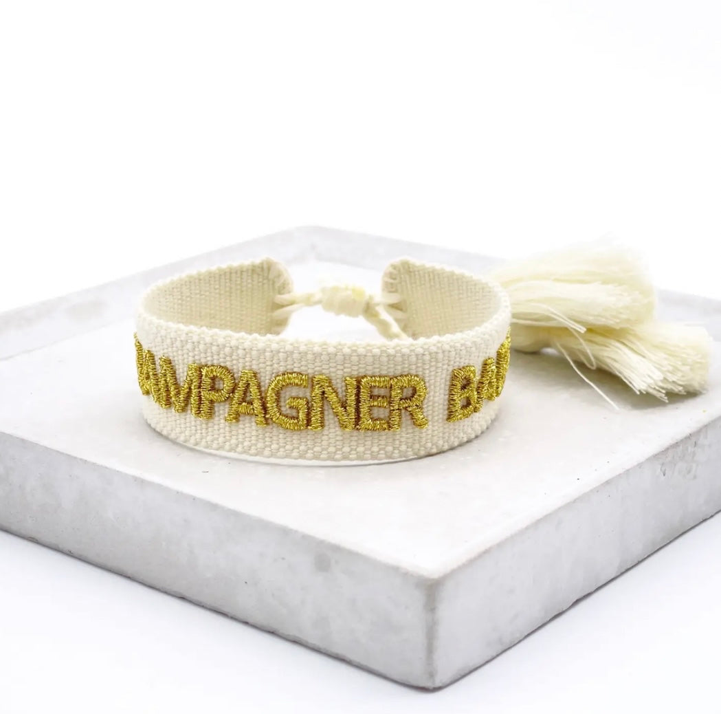 Statement Armband in weiß mit goldenem Schriftzug "Champagner Baby". Über Schiebeknoten verstellbar