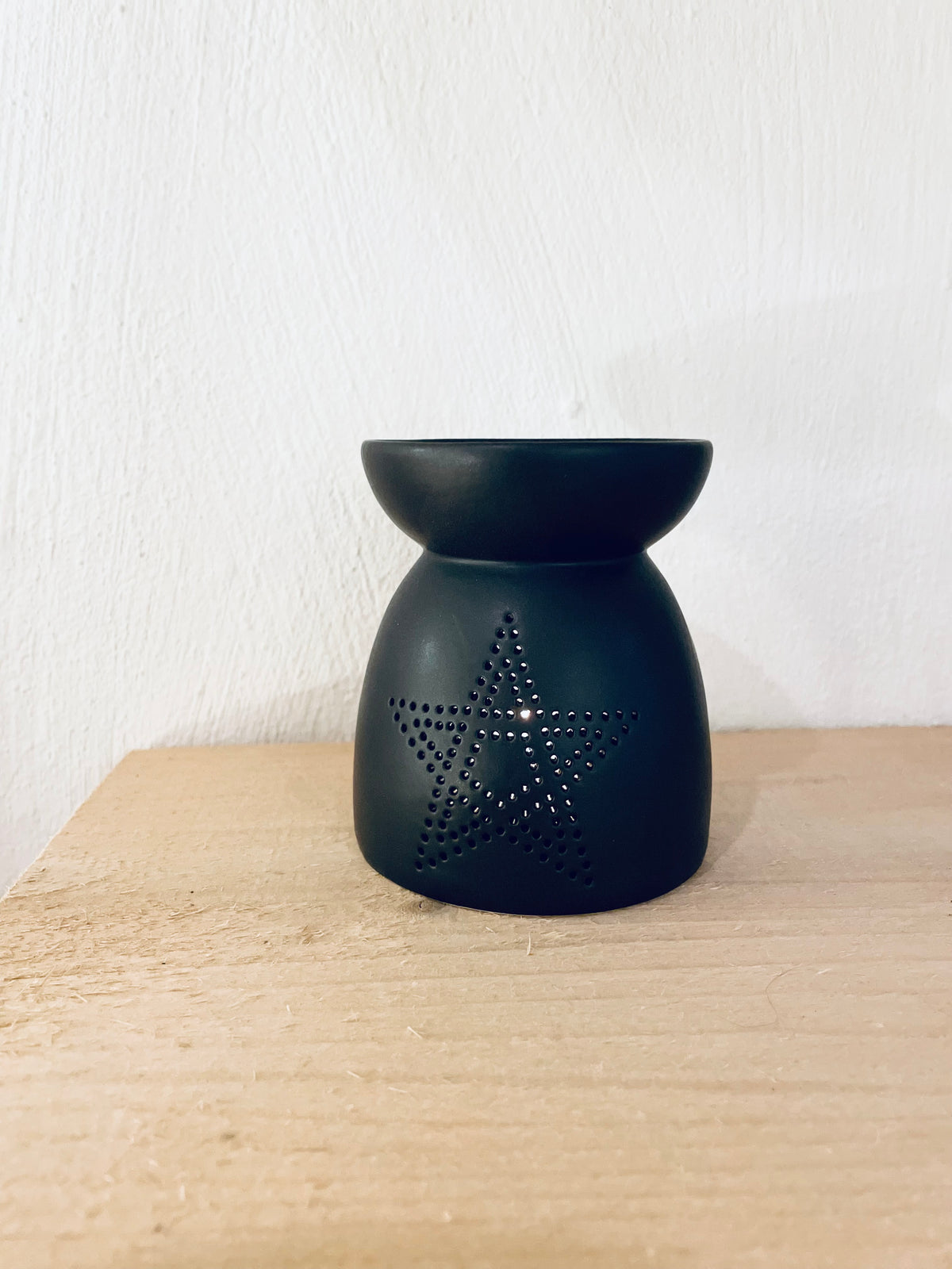 Kleine Duftlampe in Schwarz-Anthrazit auf Regal als dekoratives Wohnaccessoire