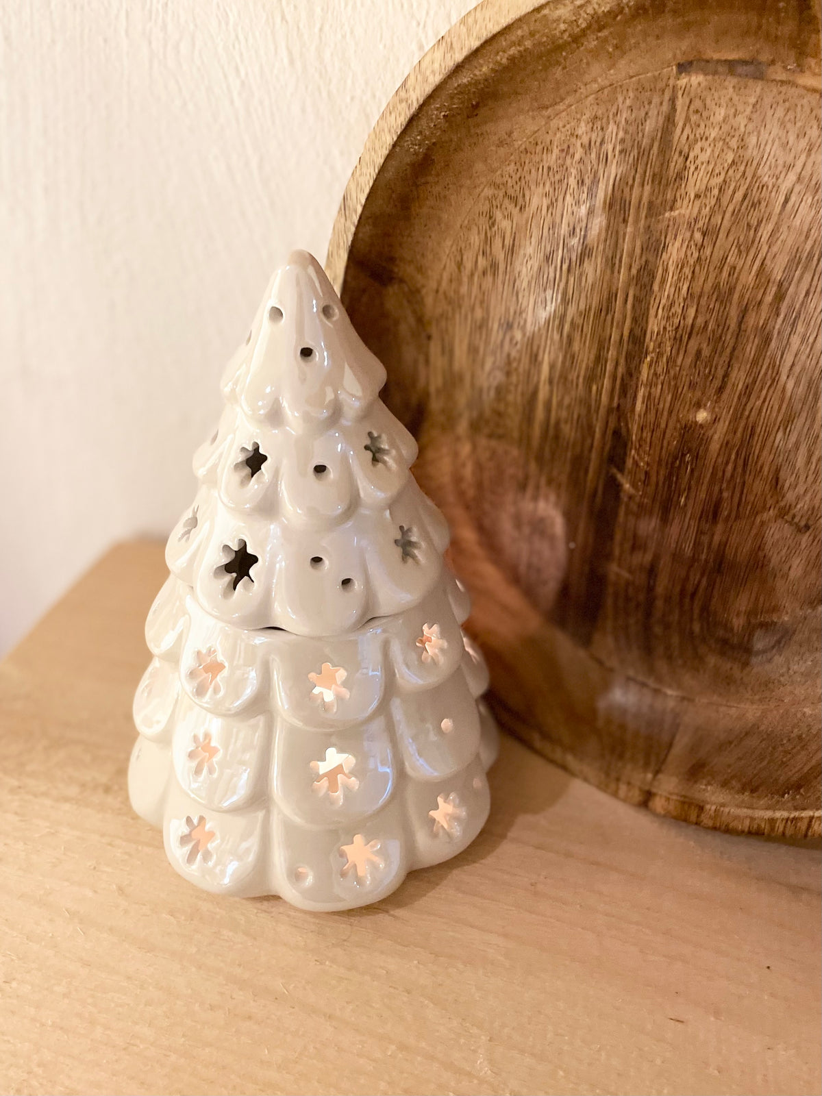 Weißer Duftlampen-Tannenbaum als winterliche Dekoration auf einem Holz Tisch, dezent leuchtend