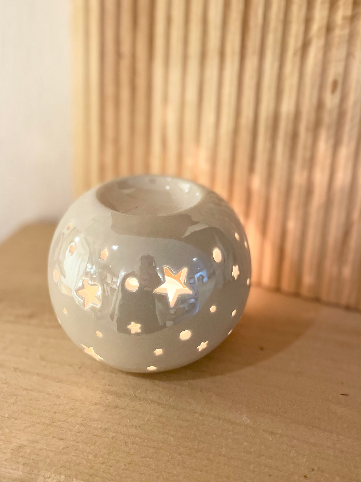Weiße runde Duftlampe mit Stern-Aussparungen und irisierender Glasur, Frontansicht