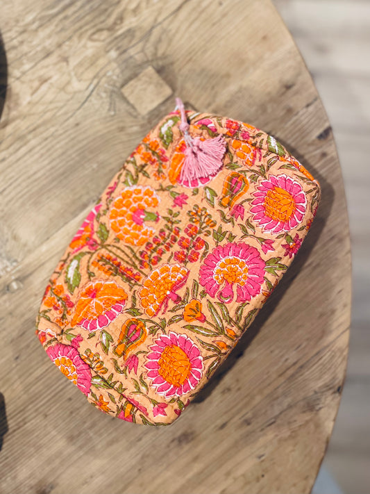 Praktische knallig orange Kulturtasche im Ripp-Design mit pinken Blumen. Innen mit einem wasserfesten Bezug und zwei kleinen Fächern!