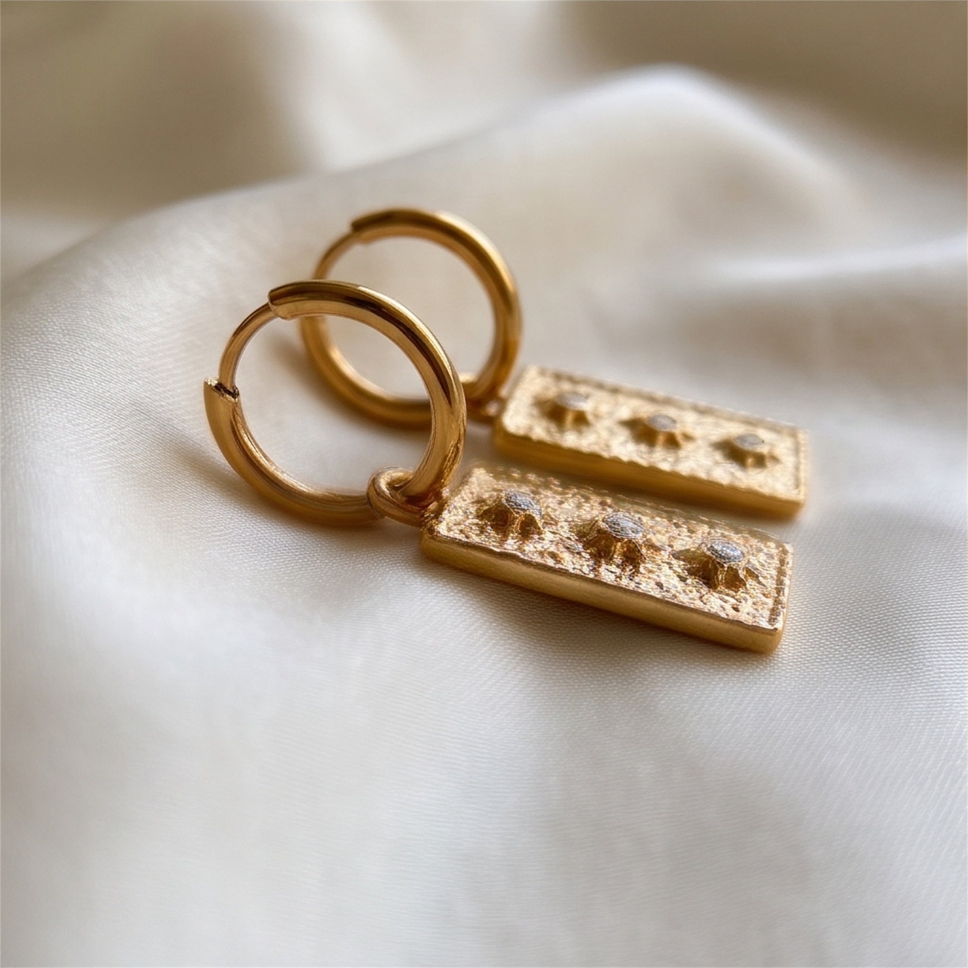  Medaillon Click-Creole aus hochwertigem Edelstahl trägt ein Medaillon im Retro-Stil, dessen gehämmerte, vergoldete Oberfläche einen edlen Glanz verleiht. Drei funkelnde, sternförmige Strass-Steinchen setzen im Medaillon kleine glitzernde Akzente 