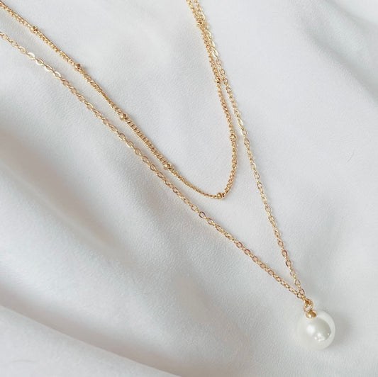 Zweireihige goldene Edelstahlkette mit einer filigranen Gliederkette mit kleinen Edelstahlkügelchen und einer feinen Gliederkette mit eingefassten Perlenanhänger.