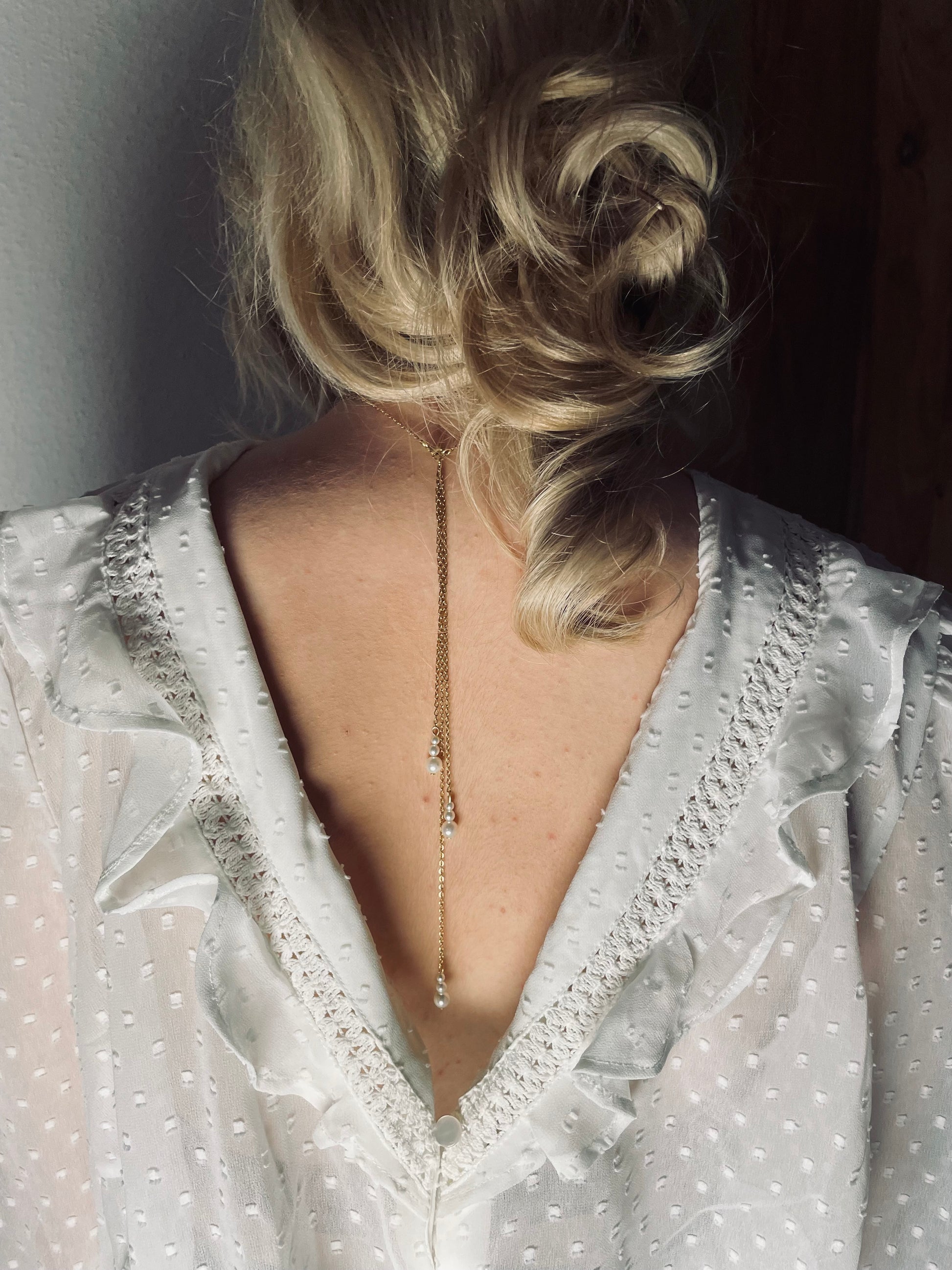 Rücken Halskette mit feiner Gliederkette mit einer Perle und zwei klaren Kristallperlen vorne. Im Rückenbereich mit drei unterschiedlich langen hängenden Gliederketten, am Ende mit je drei unterschiedlich großen Perlen! Rückenteil ist abnehmbar !