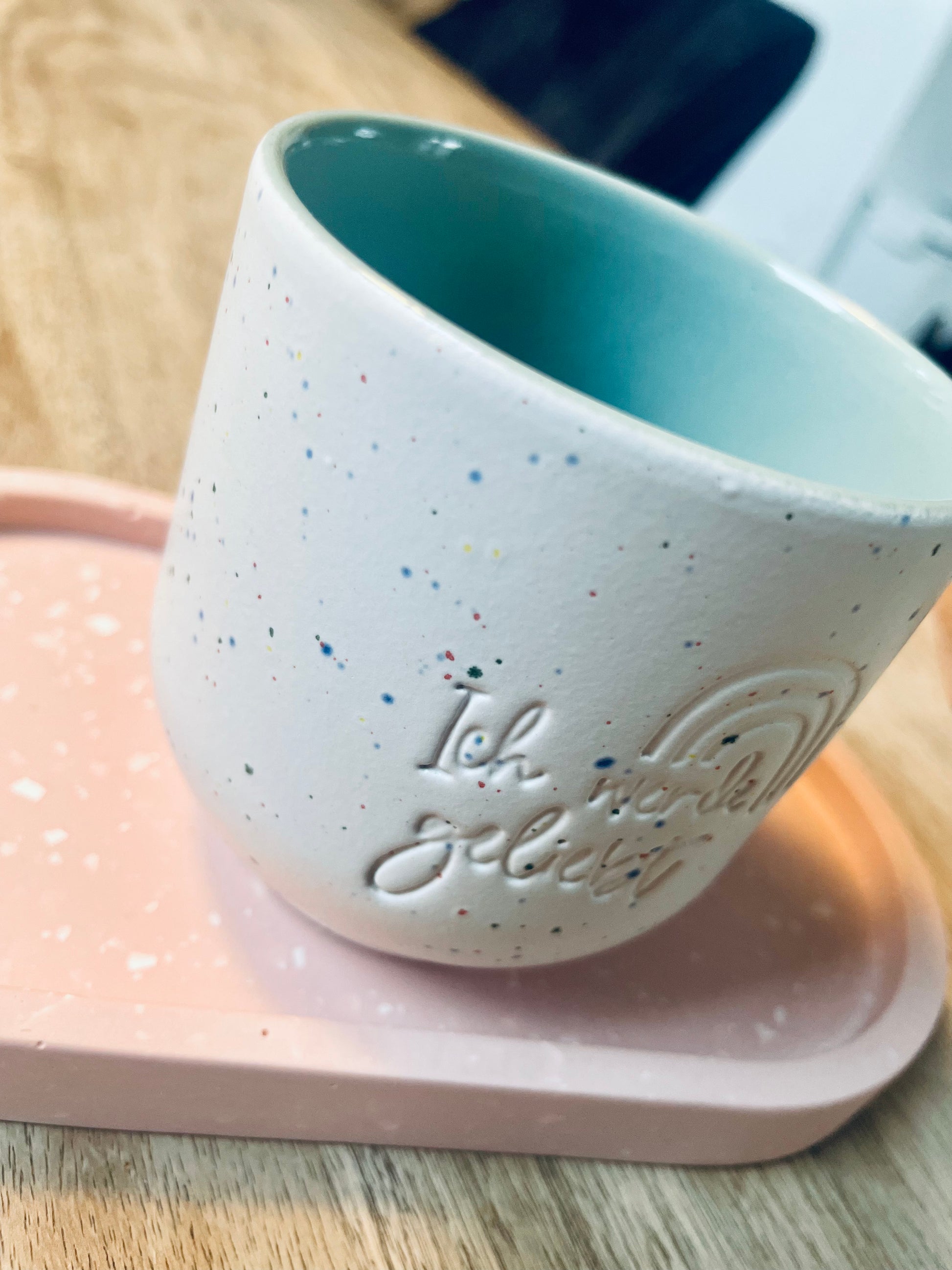 Handgemachter Keramik Becher von "Dear Benno" aus Steingut in der Farbe Salbei mit kleinen& fröhlichen Farbtupfern. Dazu die Aufschrift: "Ich werde geliebt"