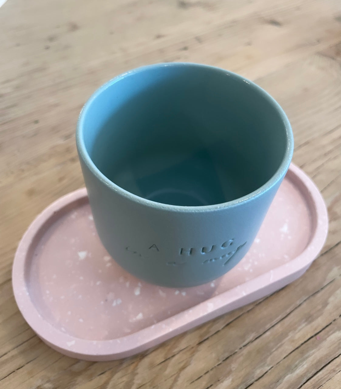 Handgemachter Keramik Becher von "Dear Benno" aus Steingut in der Farbe: Salbei Außen matt innen glänzend  Dazu die Aufschrift: "A Hug in a Mug"