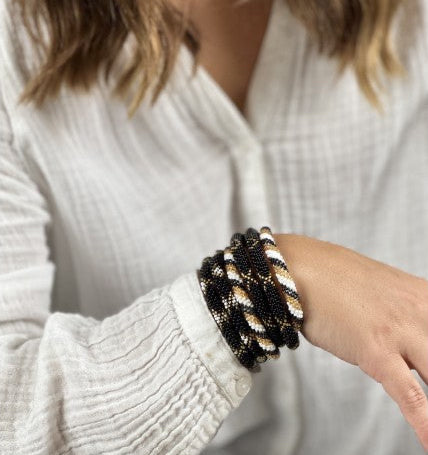Schwarz-goldenes Boho Glasperlenarmband aus Nepal ohne Verschluss am Handgelenk getragen