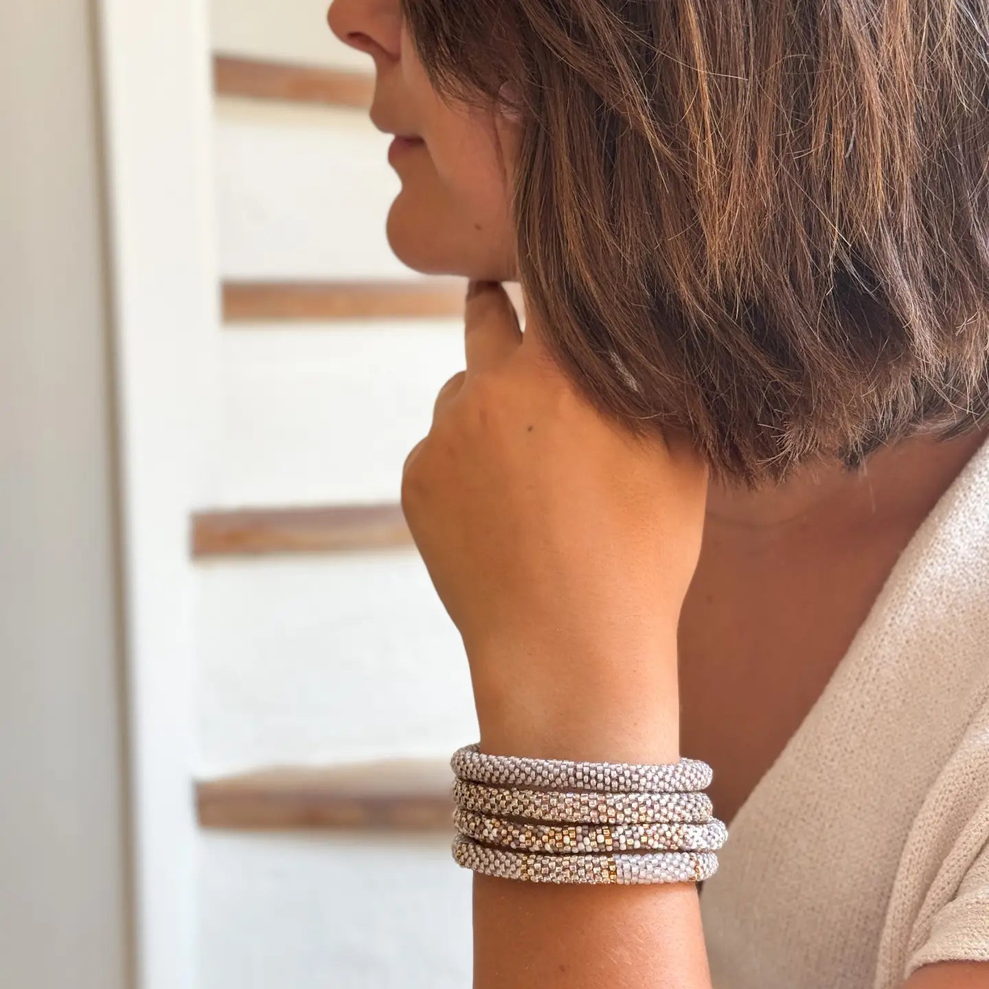 Nahaufnahme eines dehnbaren Glasperlenarmbands ohne Verschluss in den Farben Grau und Gold
