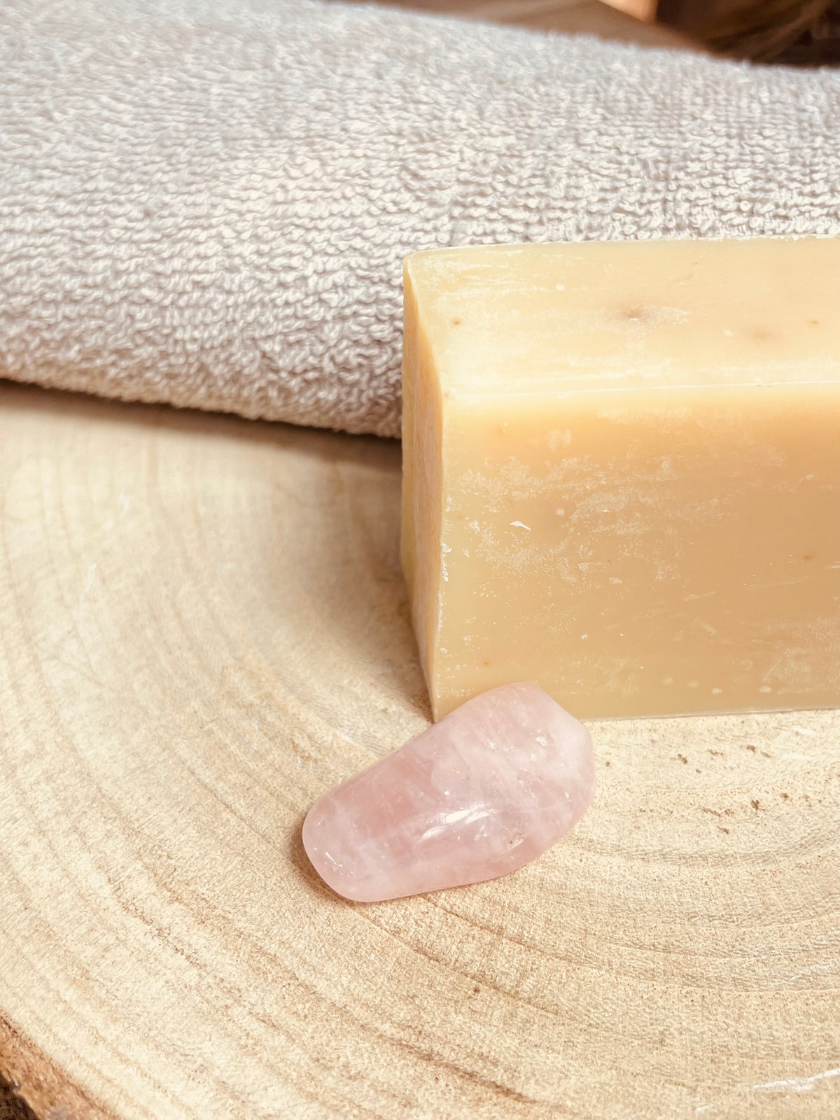 Blumug riechende Milchseie Edelweis liegend auf Holz mit Rosenquarz Stein der Liebe.